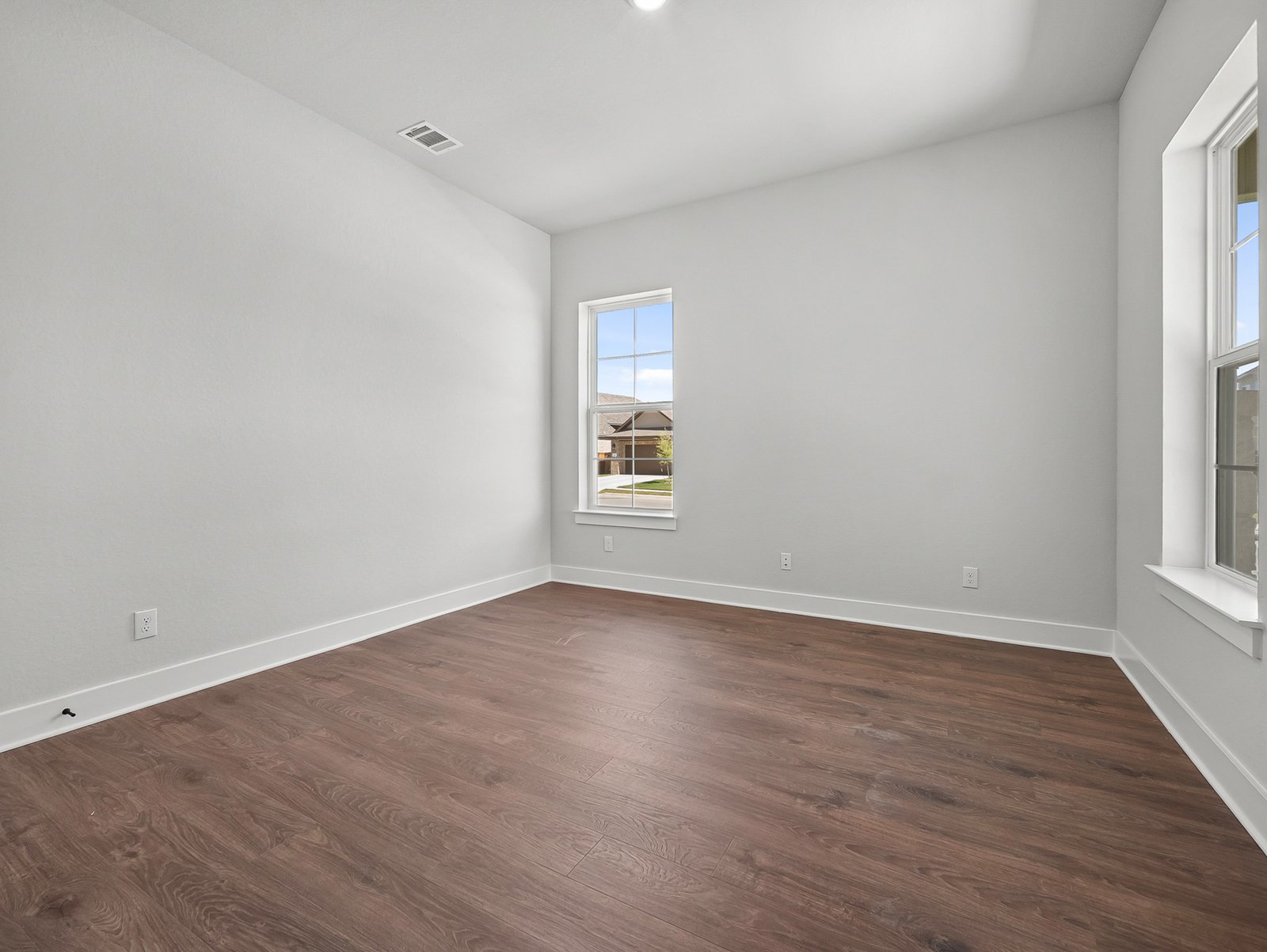 study with brown flooring, windows & recessed lighting