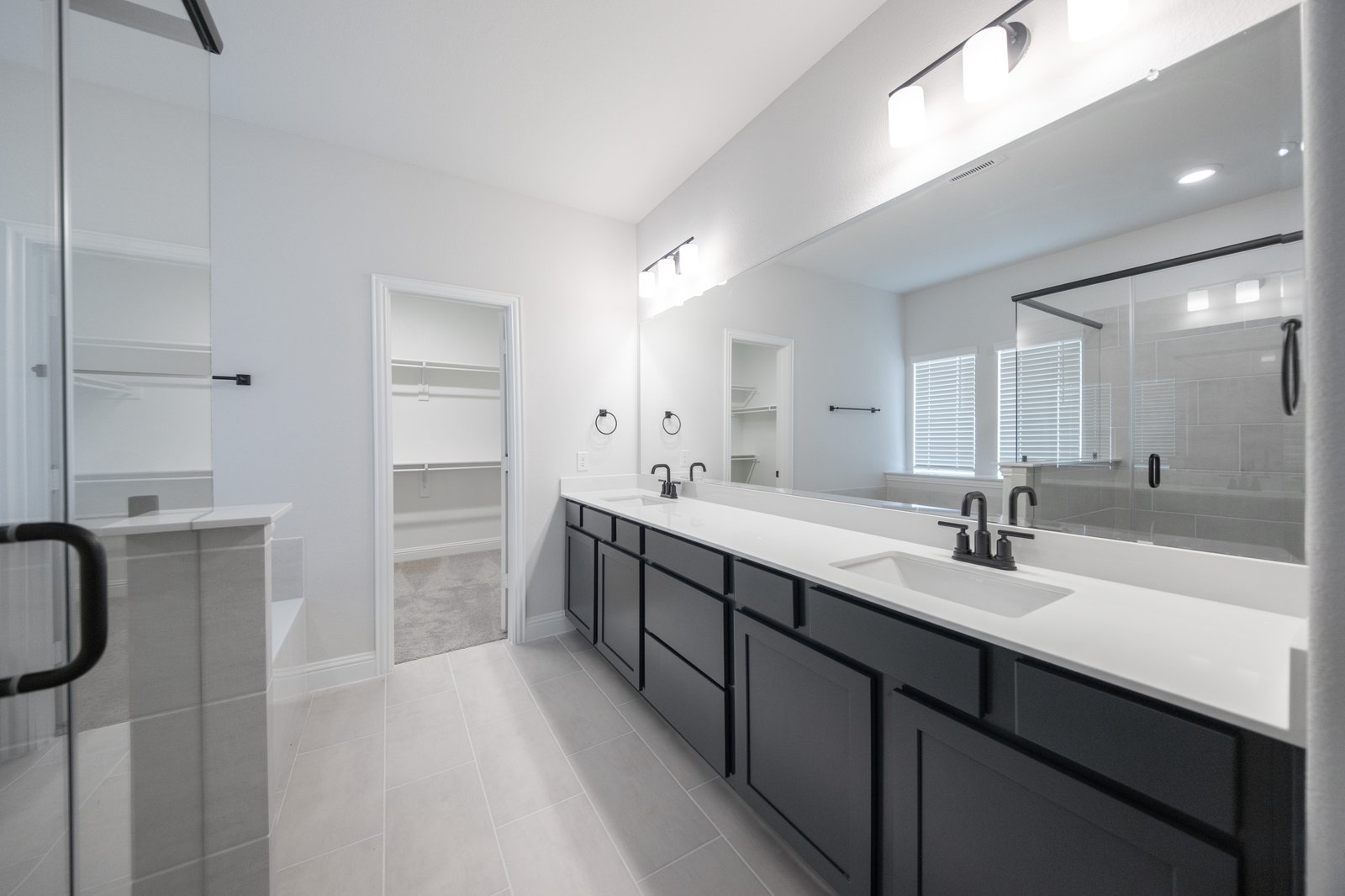 bathroom with large mirror and white countertops