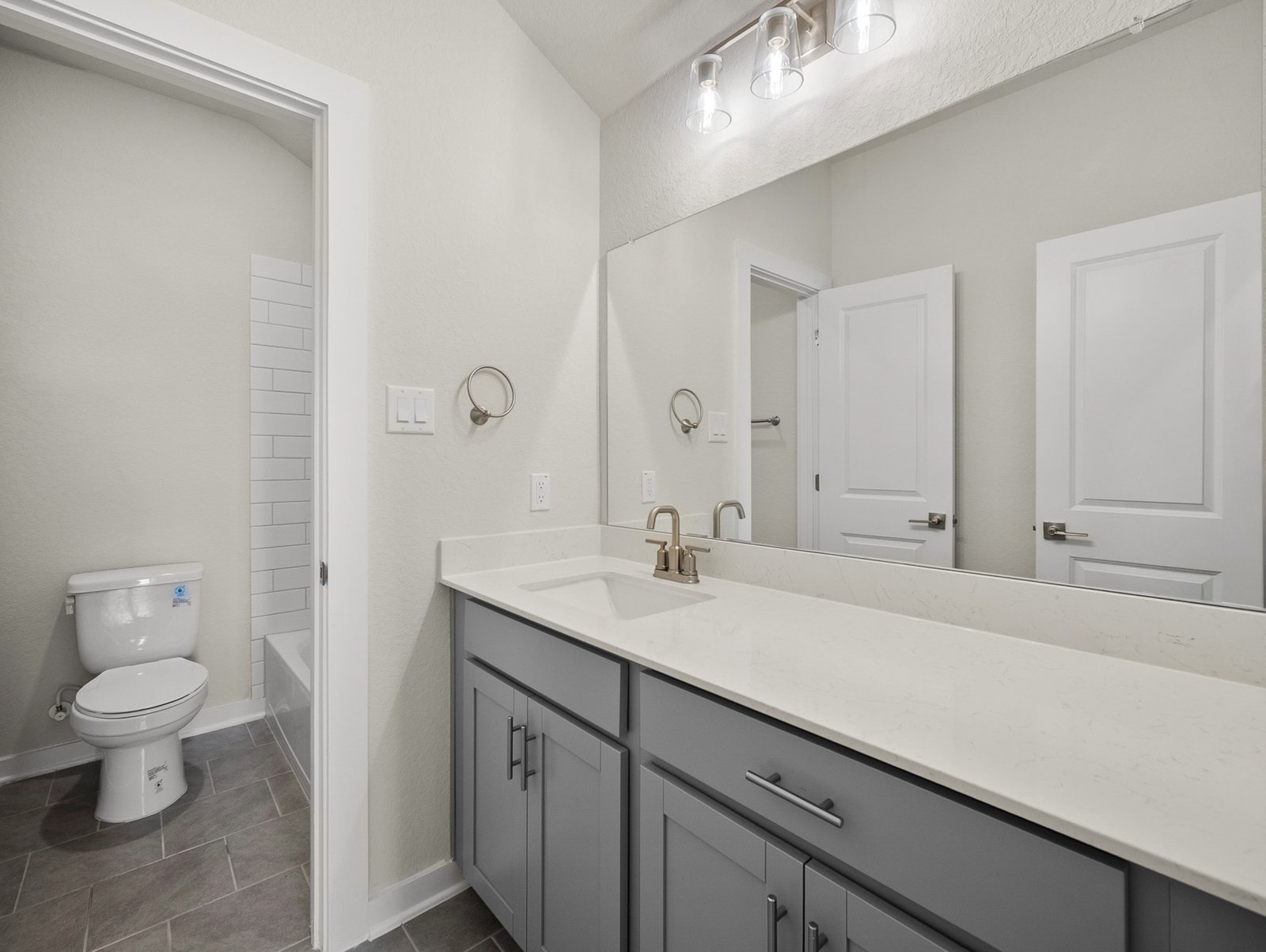 bathroom with quartz countertops & a bathtub with shower combo