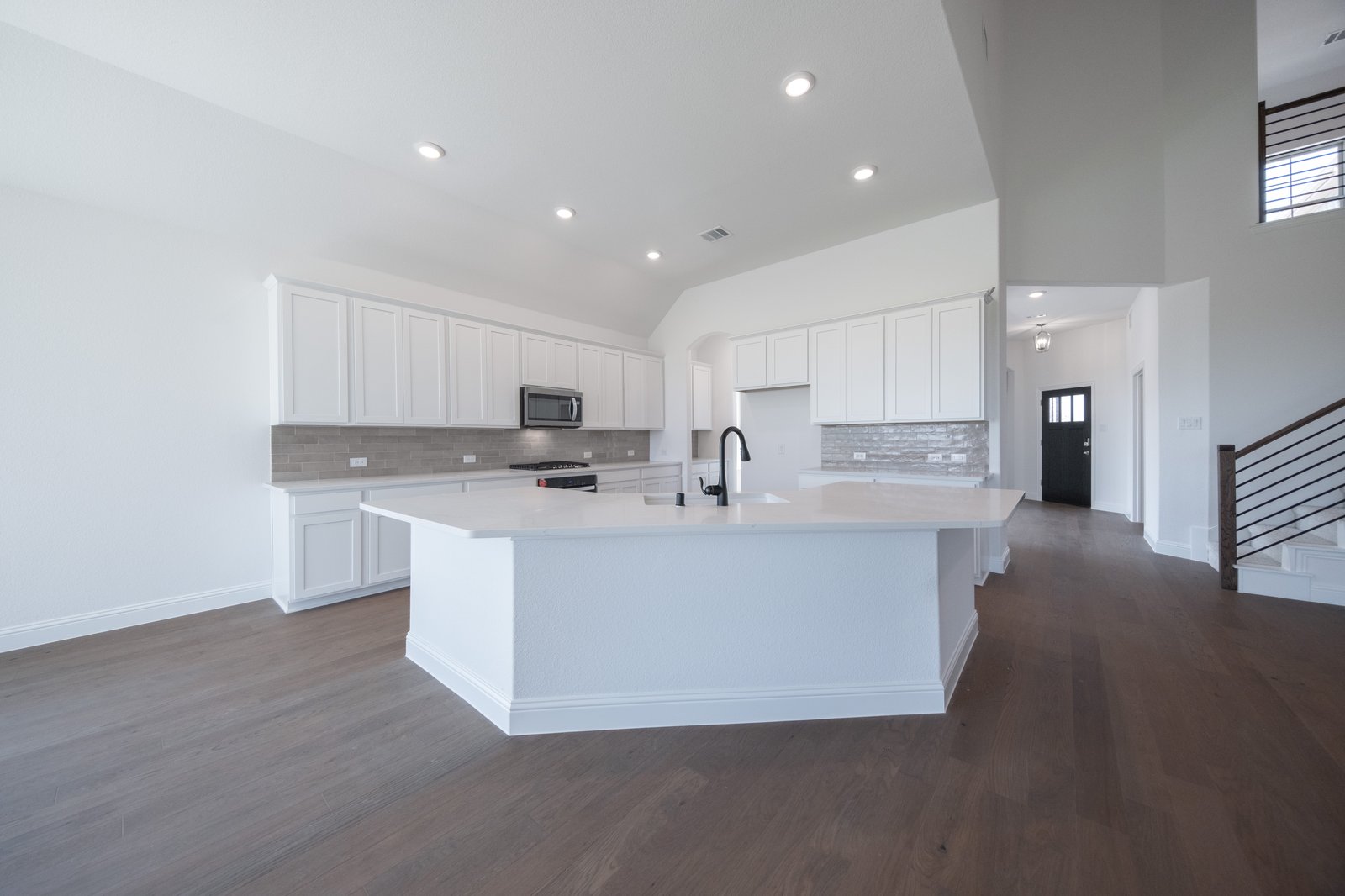 open kitchen with white cabinets and hardwood flooring