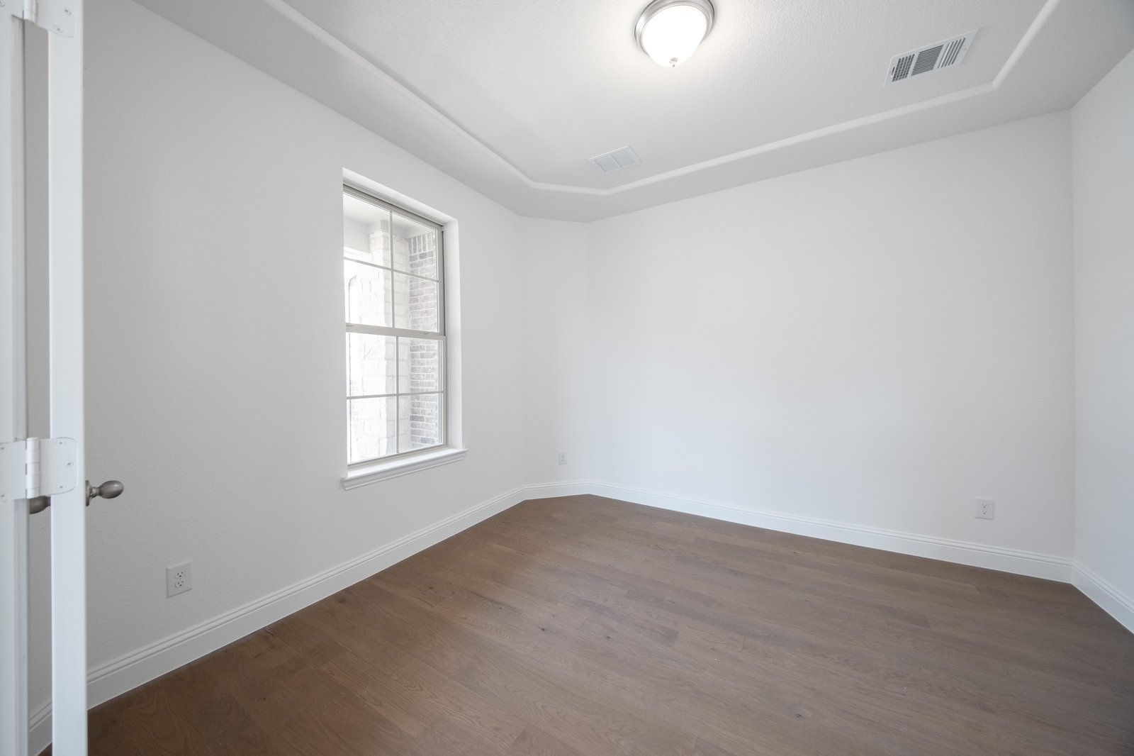 open study with hardwood flooring and glass french doors