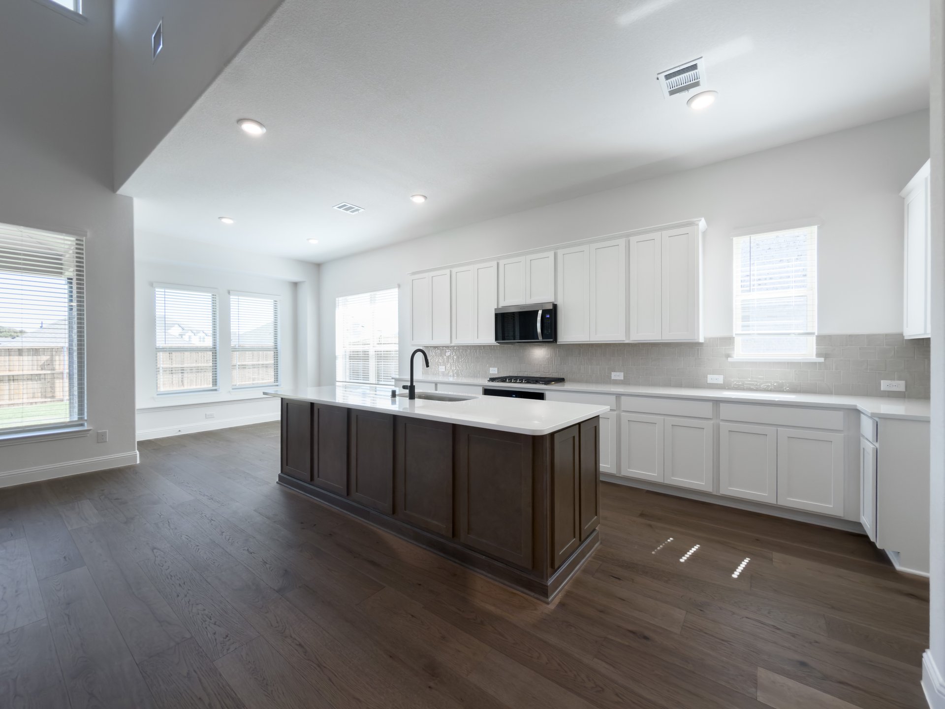 open kitchen with white cabinets and hardwood flooring
