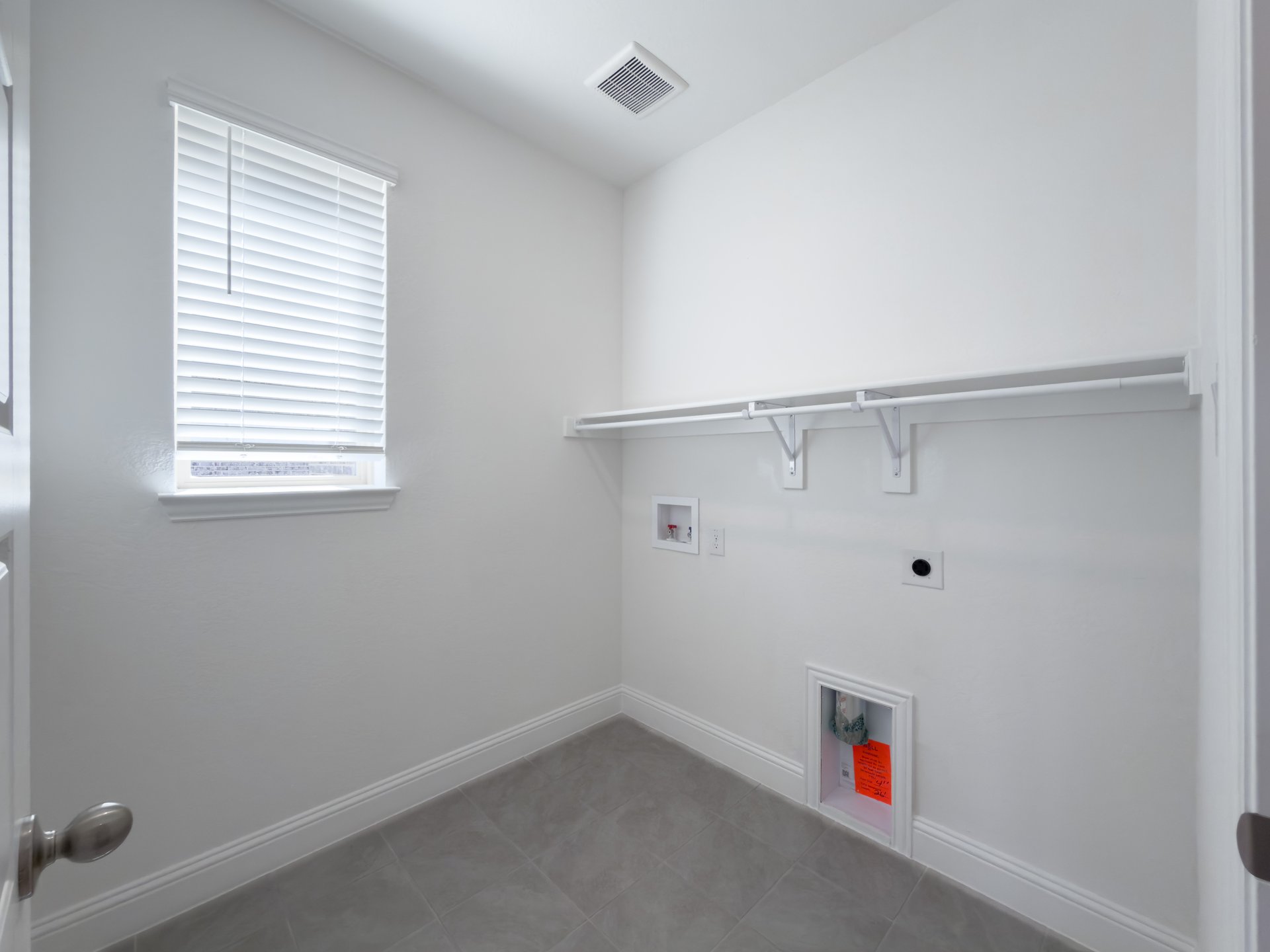 laundry room with tile flooring and storage shelf