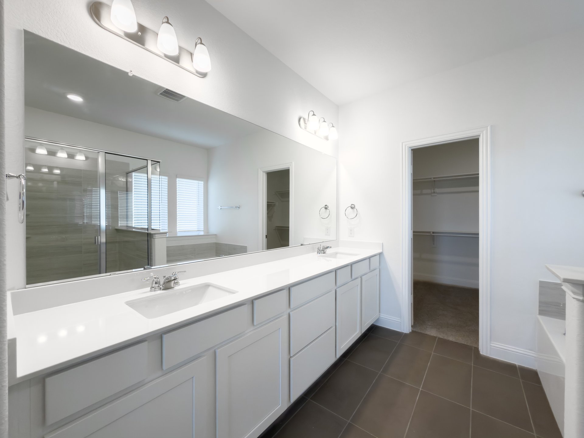 primary bathroom with double sinks and tile flooring