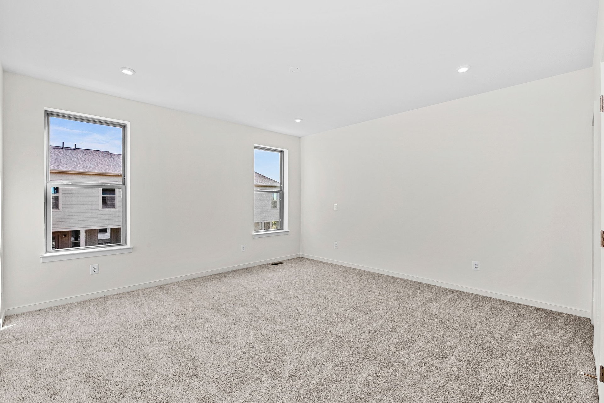 primary bedroom with multiple windows and carpet
