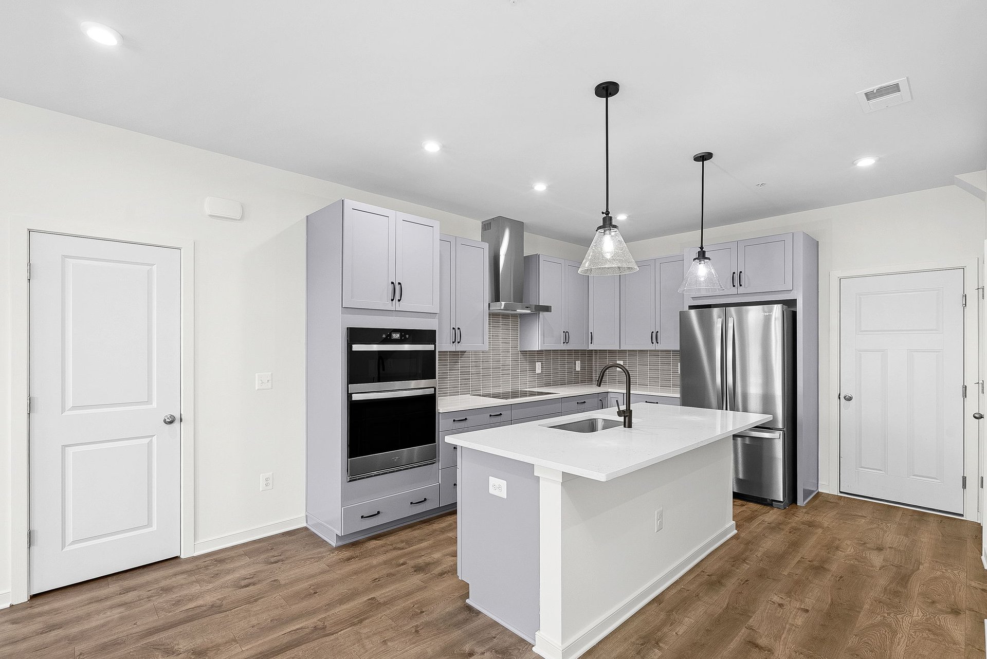 kitchen with an island with a sink and pendant lighting