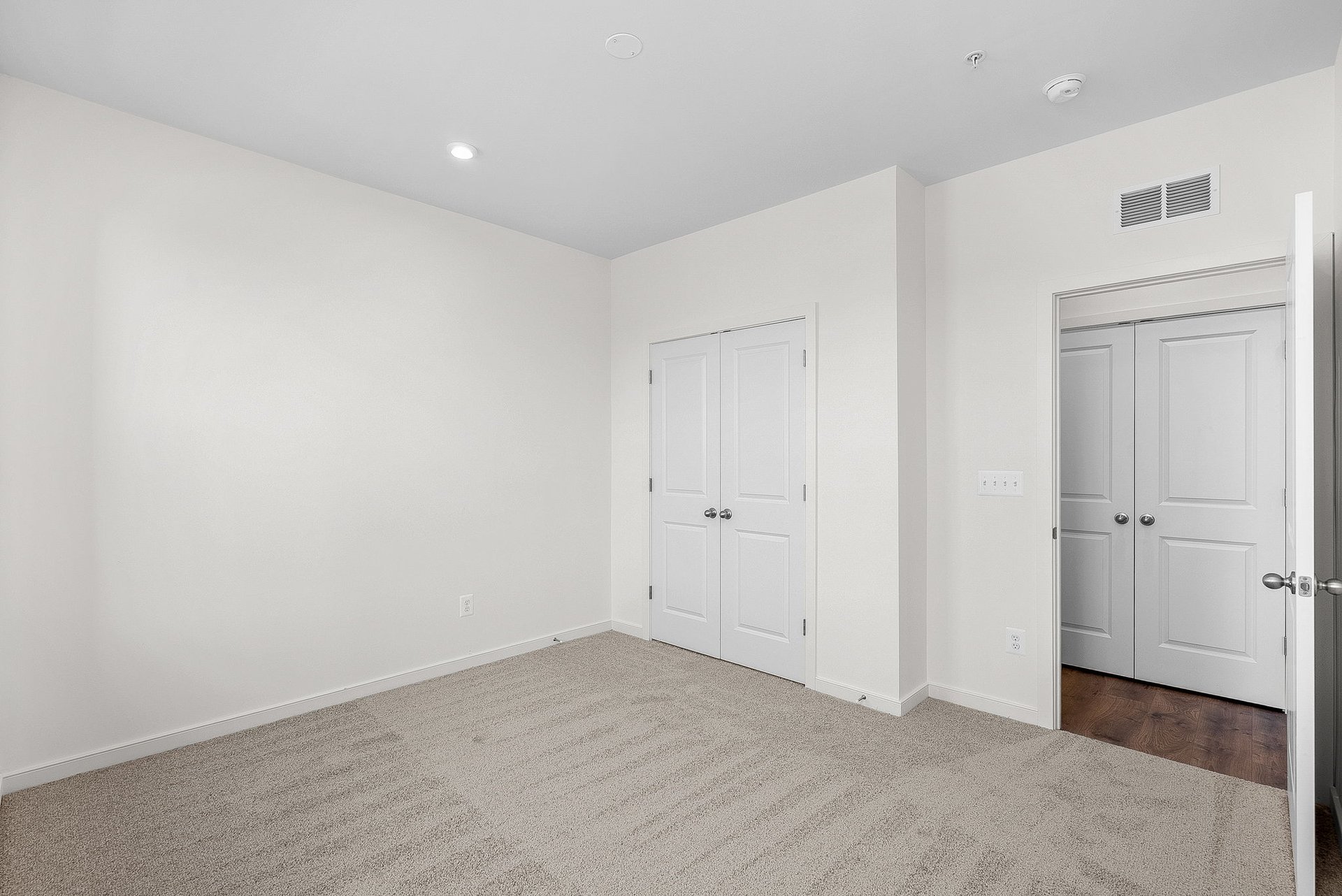 secondary bedroom with closet with two doors and door opening to hallway