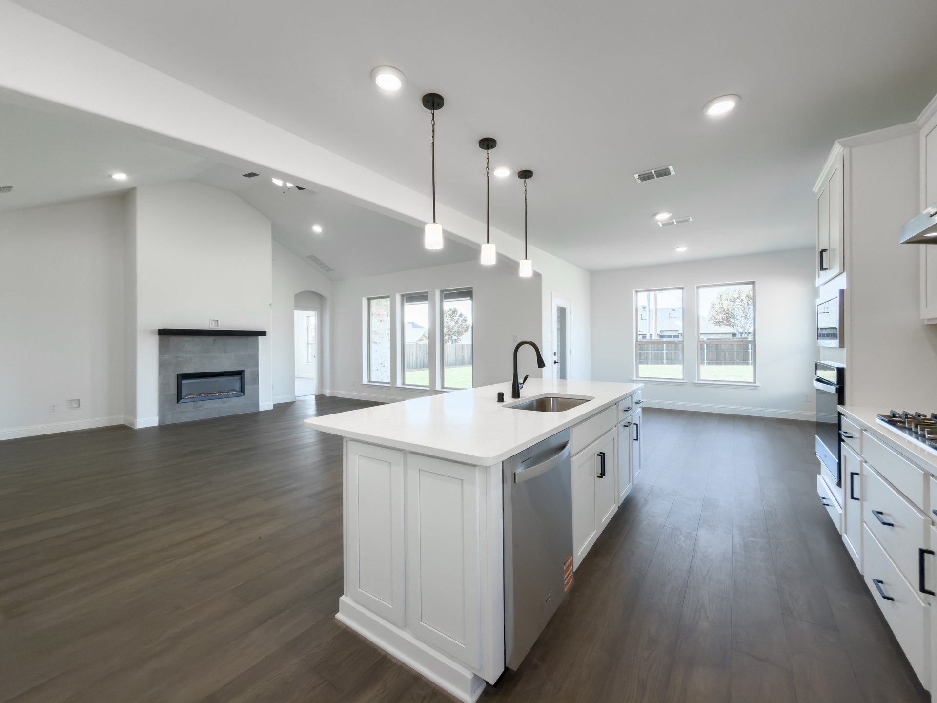 open kitchen with wood floors and white cabinets