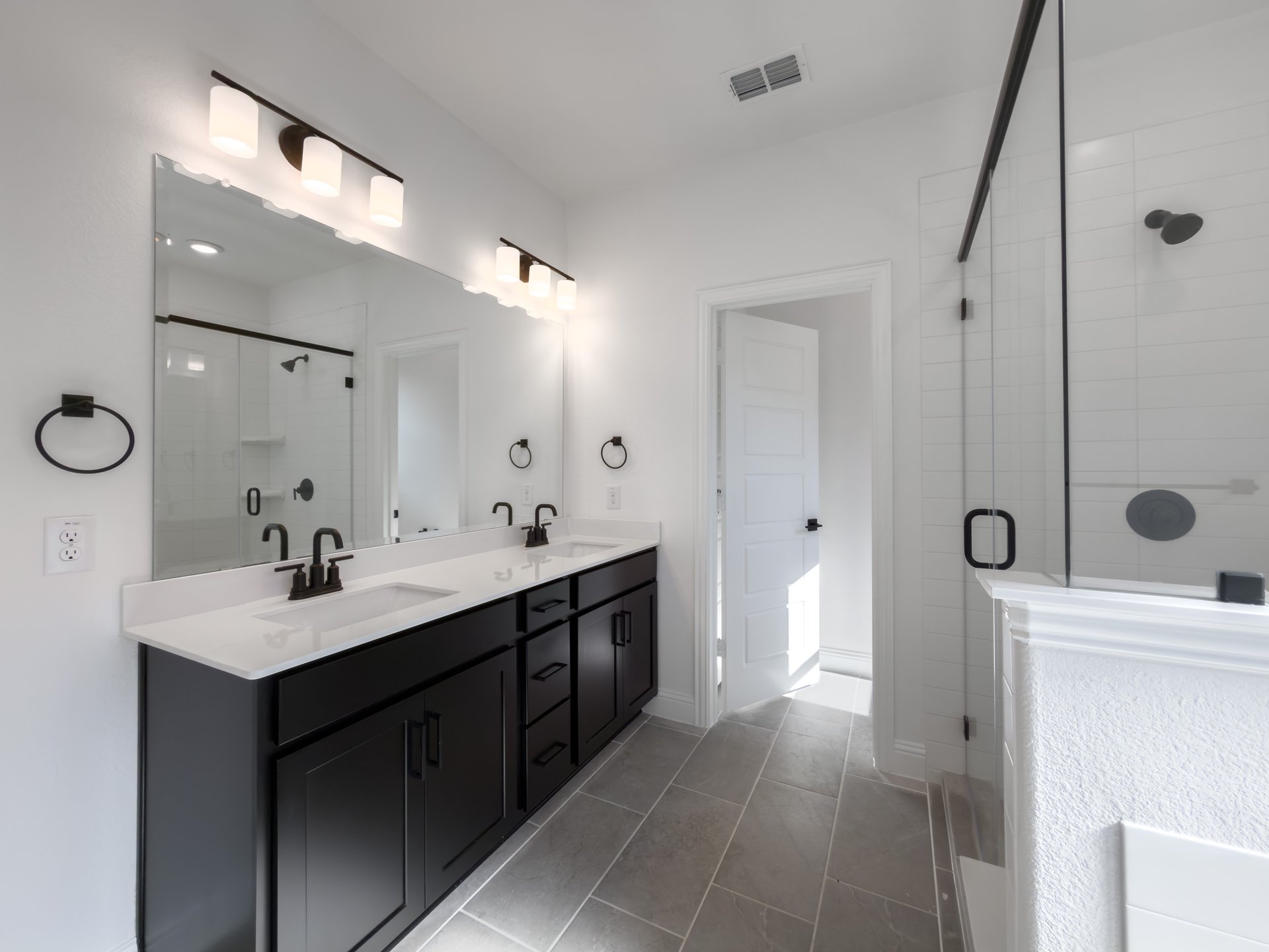 primary bathroom with two sinks and tile floors