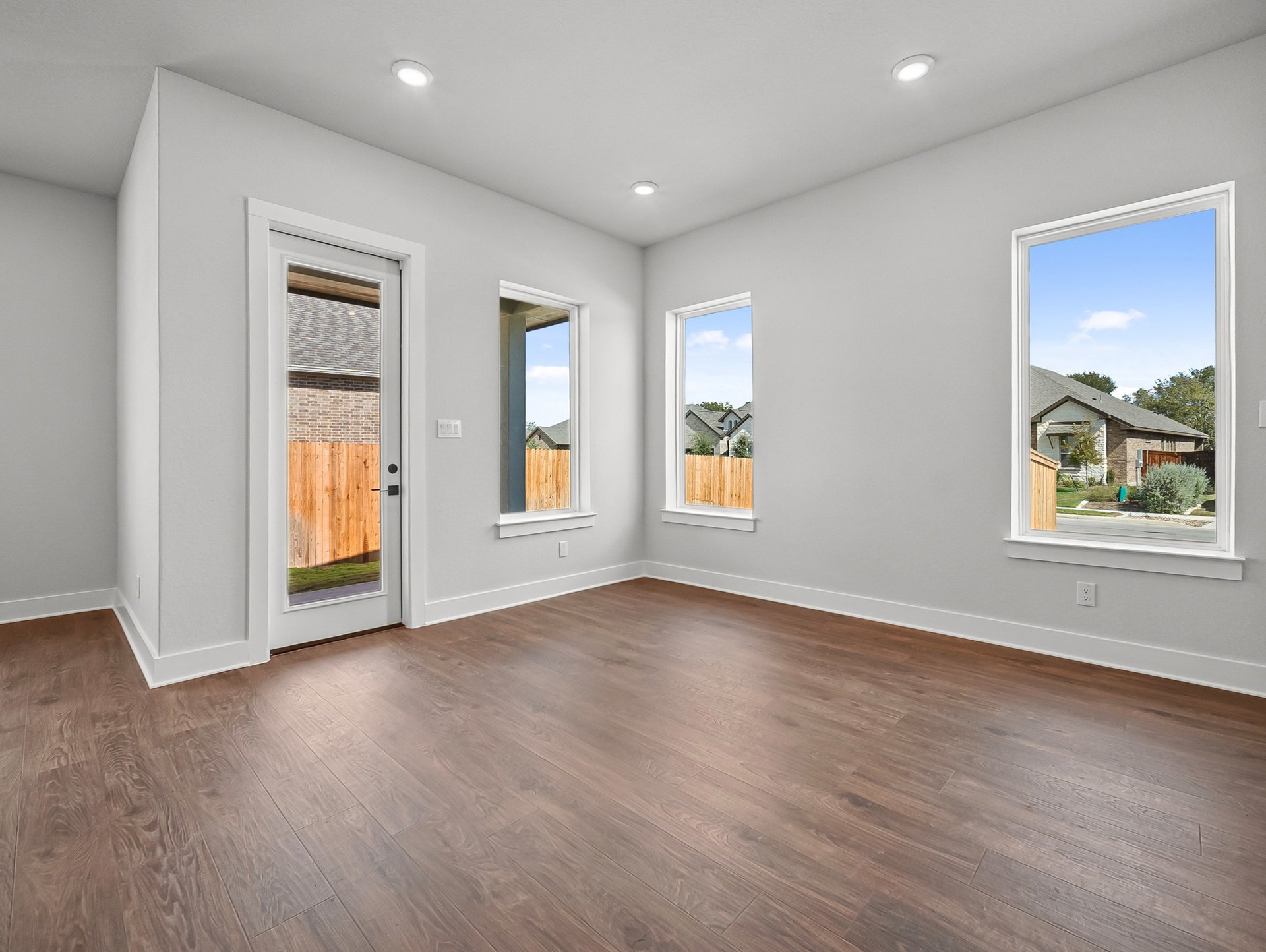 dining area with brown flooring, windows & recessed lighting