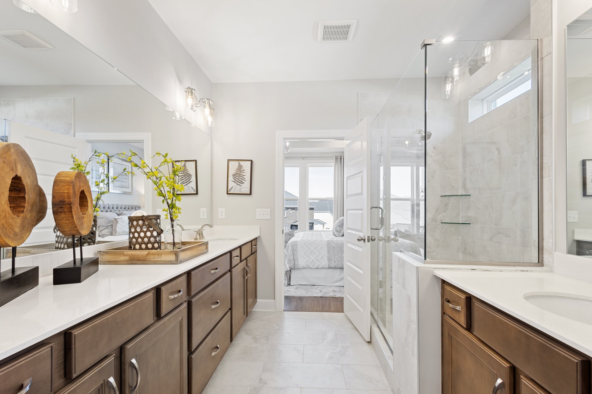 primary bathroom with tile flooring, a walk-in shower, and direct access to the walk-in closet