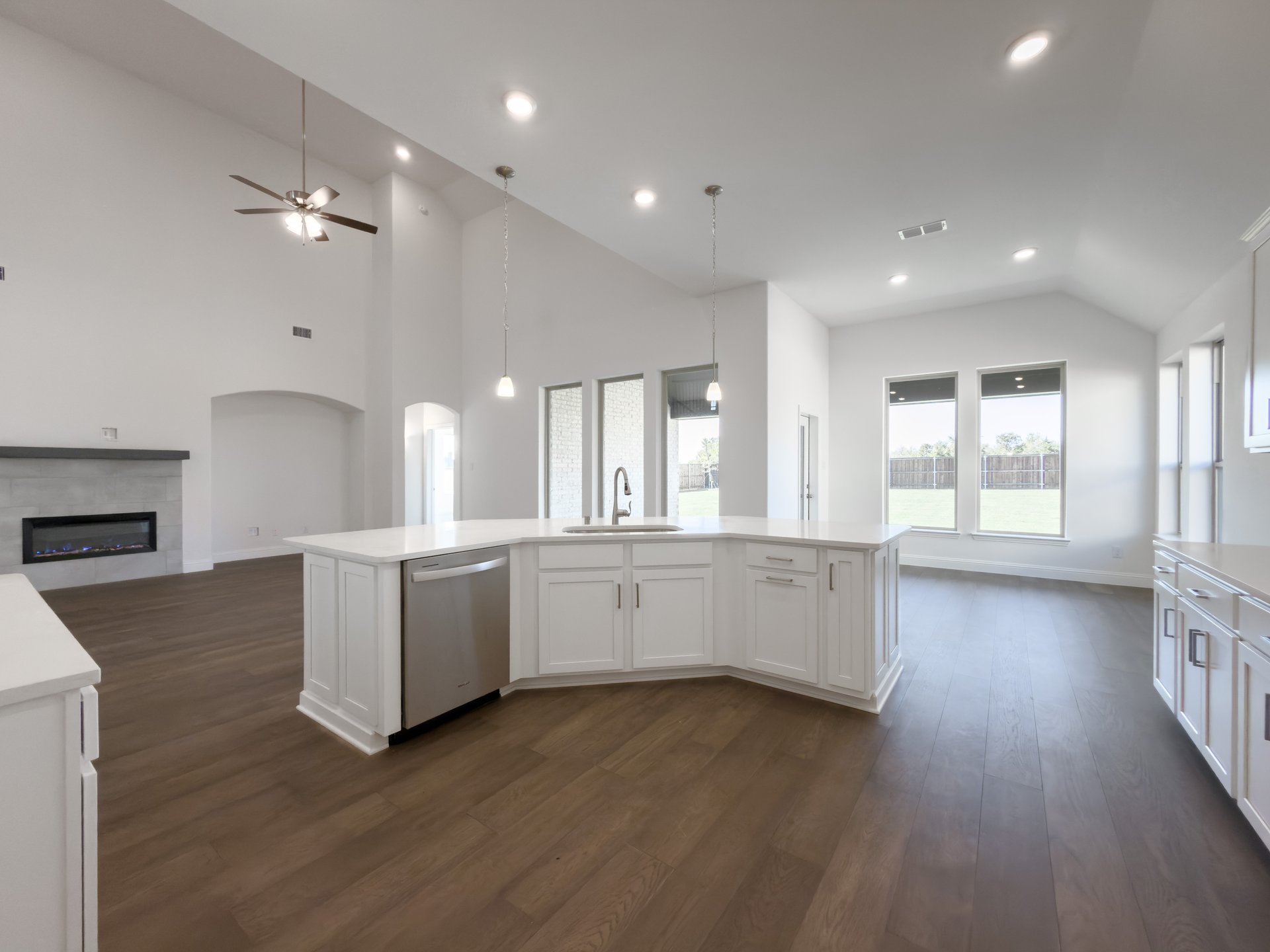 open kitchen with wood floors and white cabinets