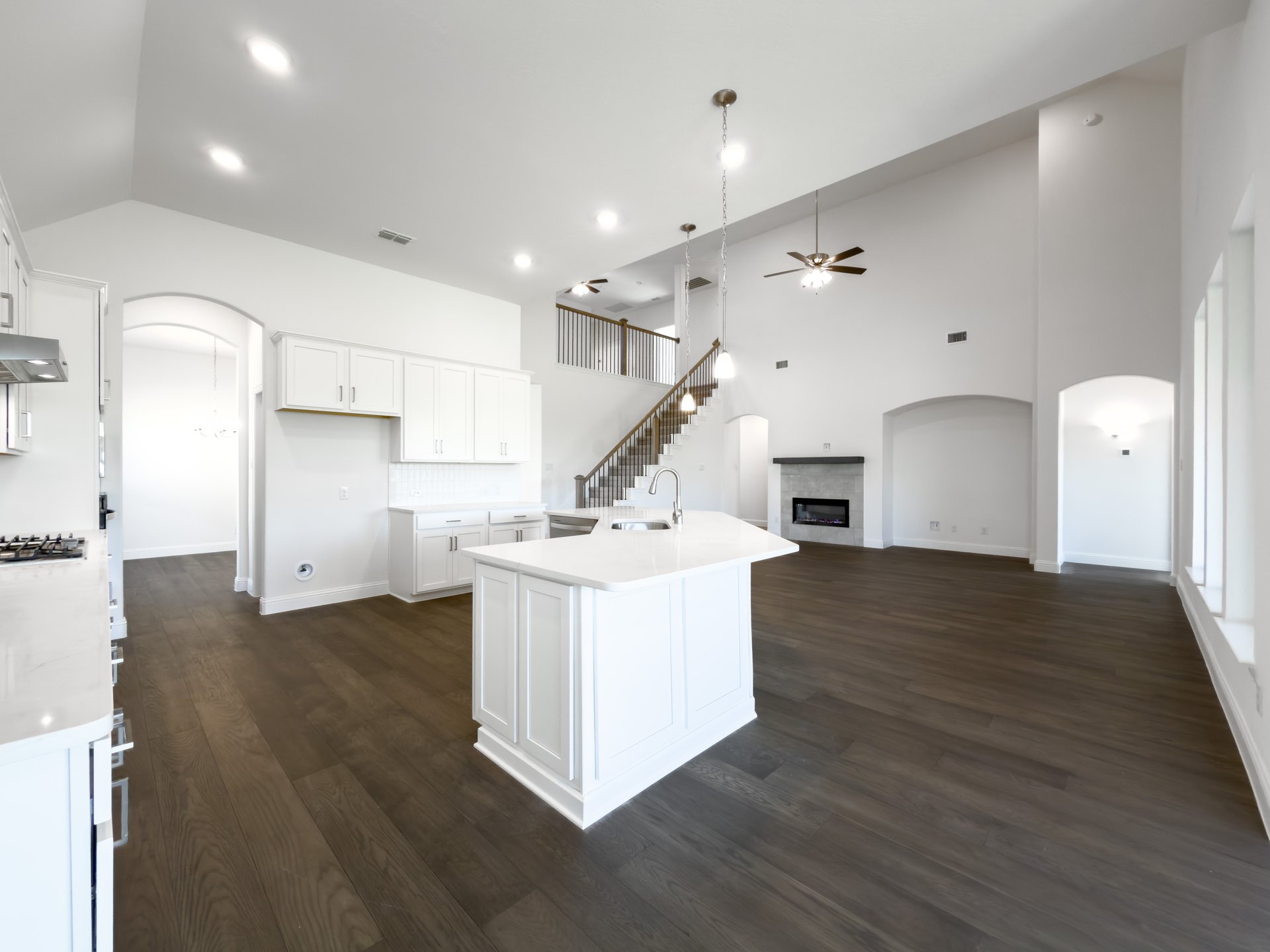 open kitchen with wood floors and white cabinets