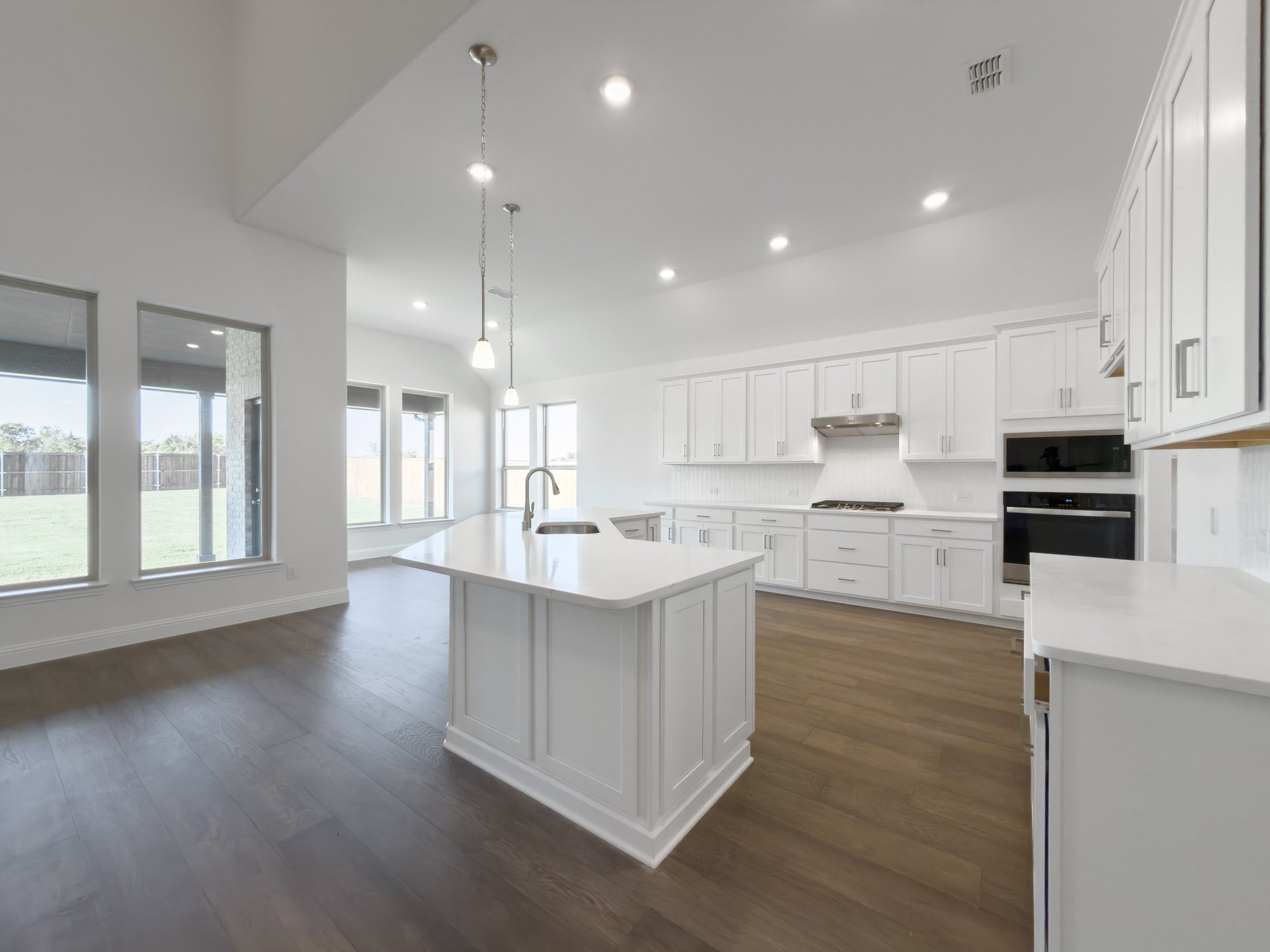 open kitchen with wood floors and white cabinets