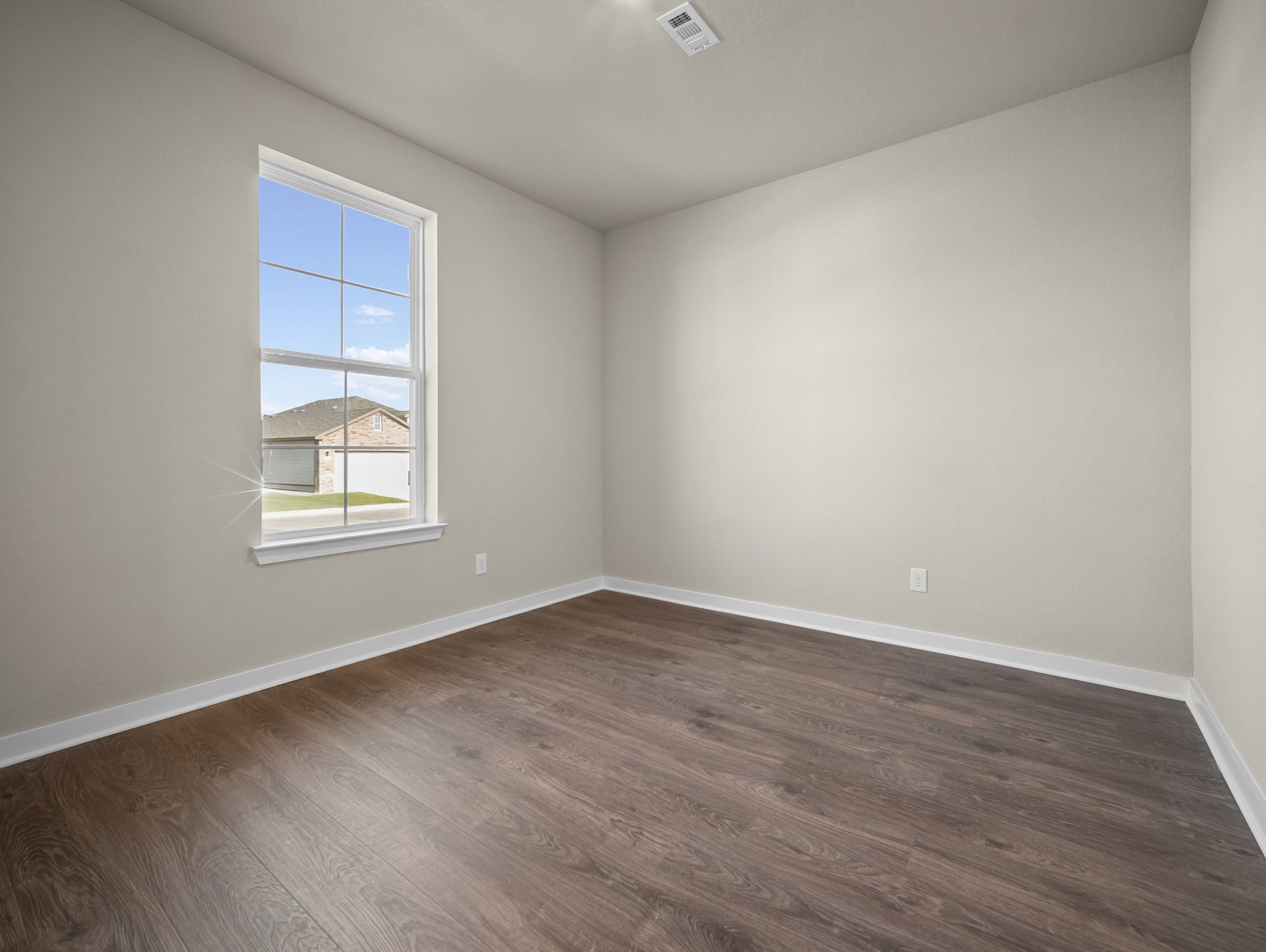 study with a window & brown flooring
