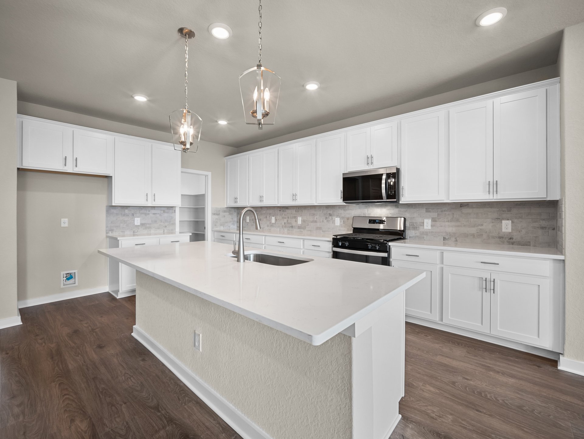 kitchen with brown flooring, pendant lighting & quartz countertops