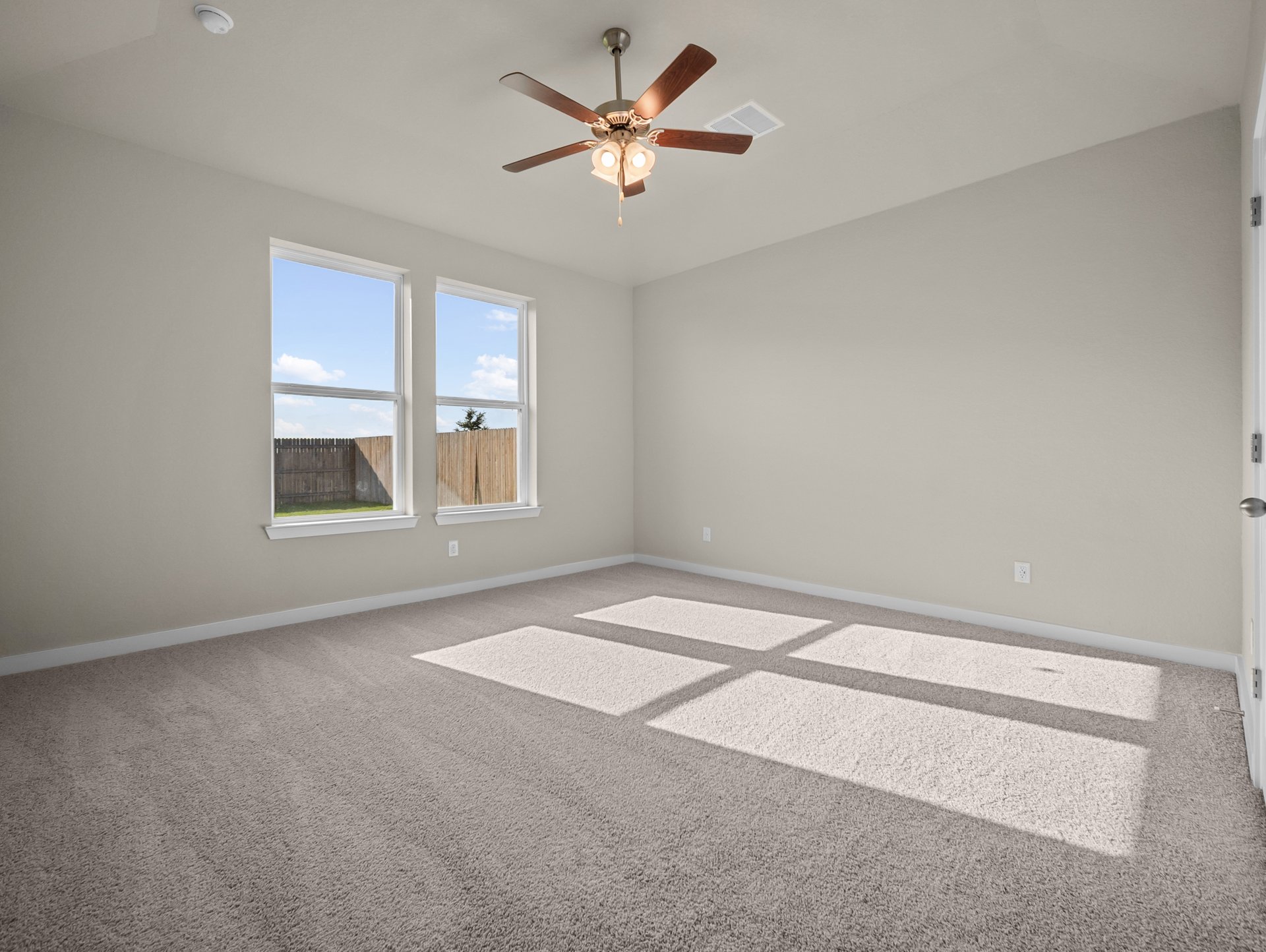 bedroom with carpet, ceiling fan & windows