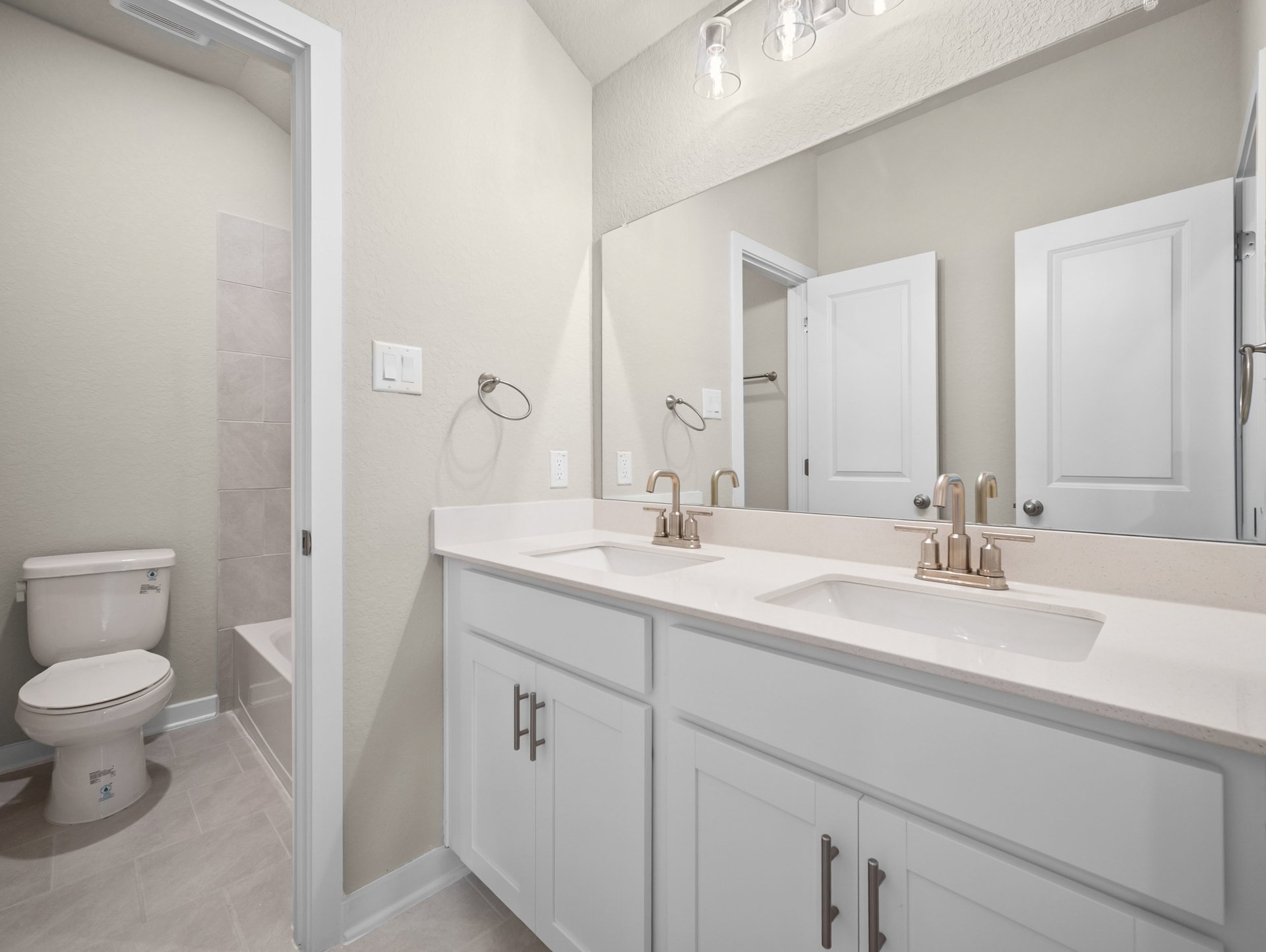 bathroom with dual sinks & a bathtub with shower combo