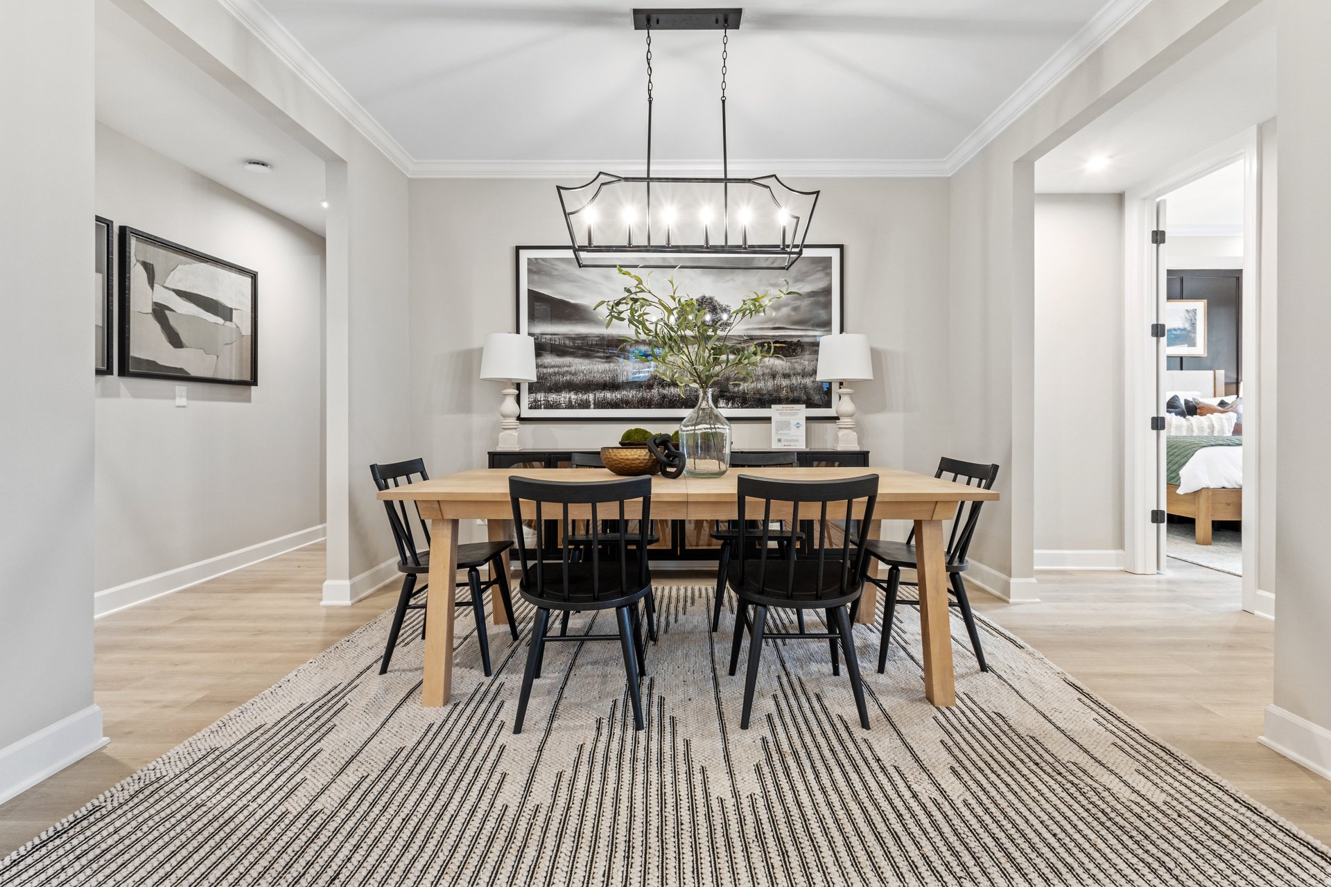 dining area with a large area rug, a wooden table, and six black chairs