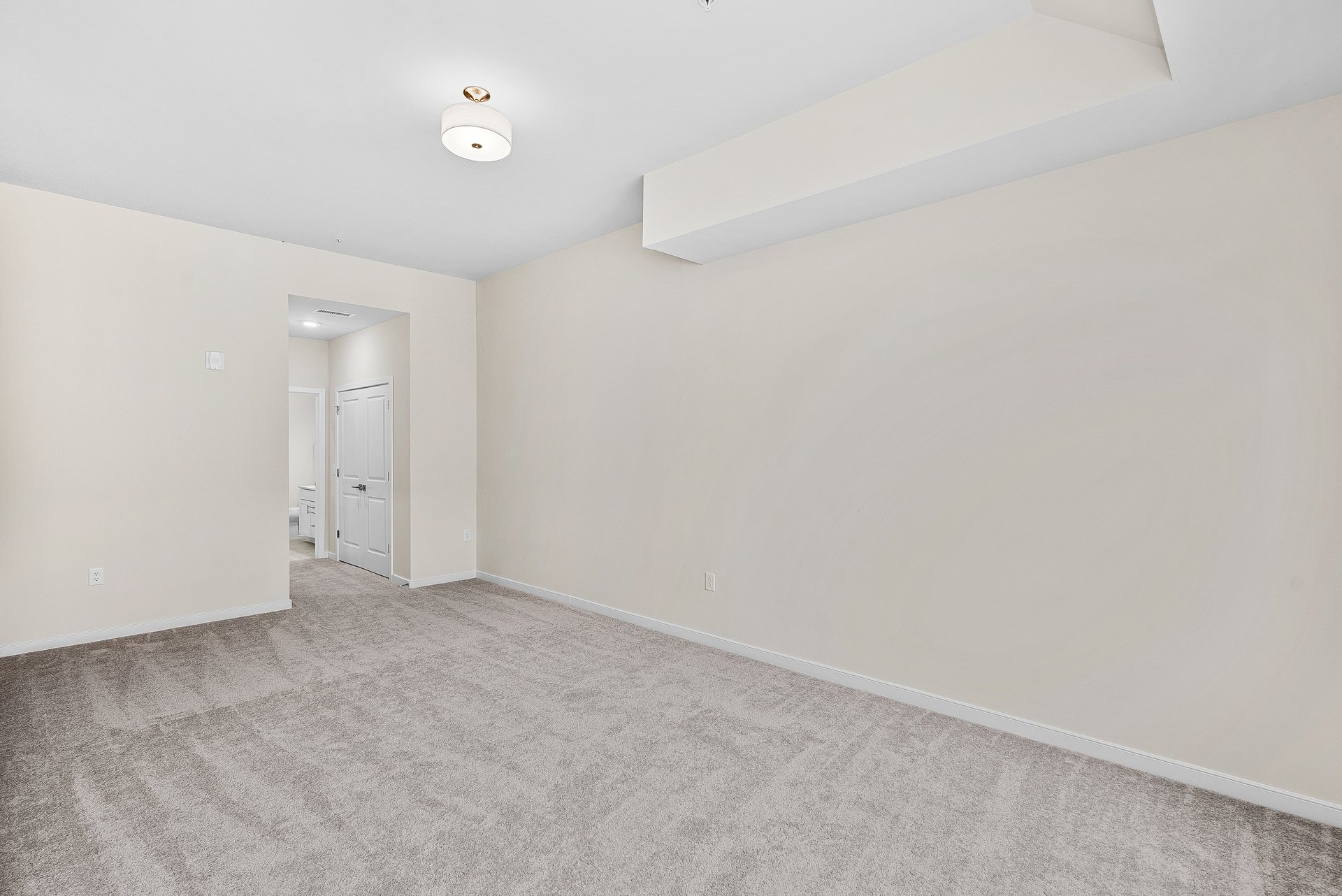 primary bedroom with overhead lighting and carpet