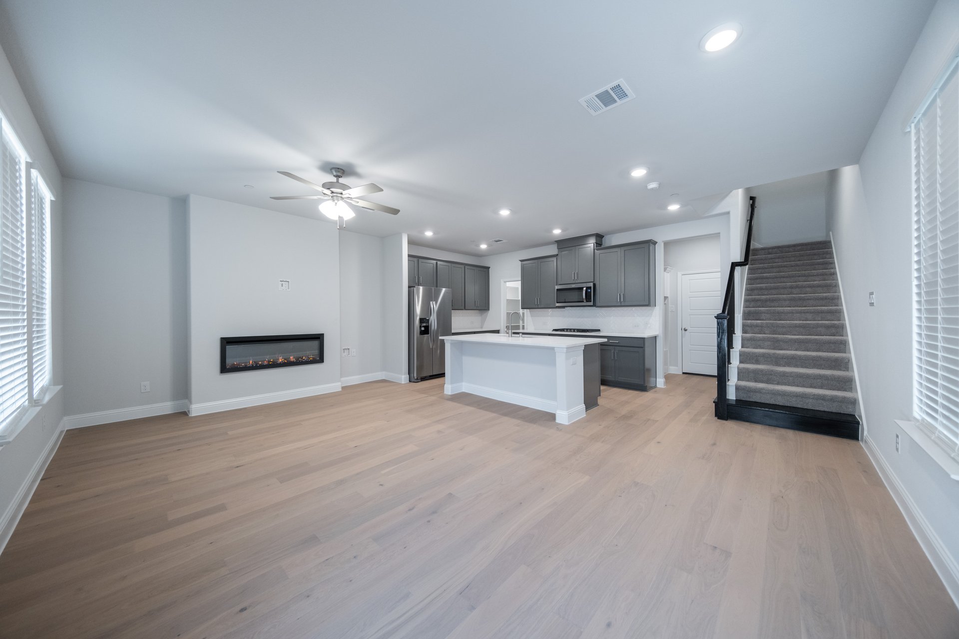 great room with electric fireplace and wood flooring 
