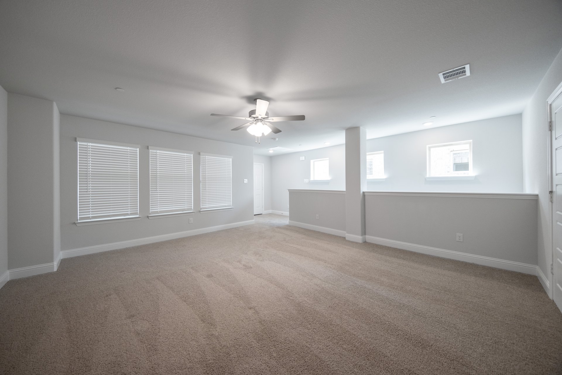 loft with windows with blinds and carpet 