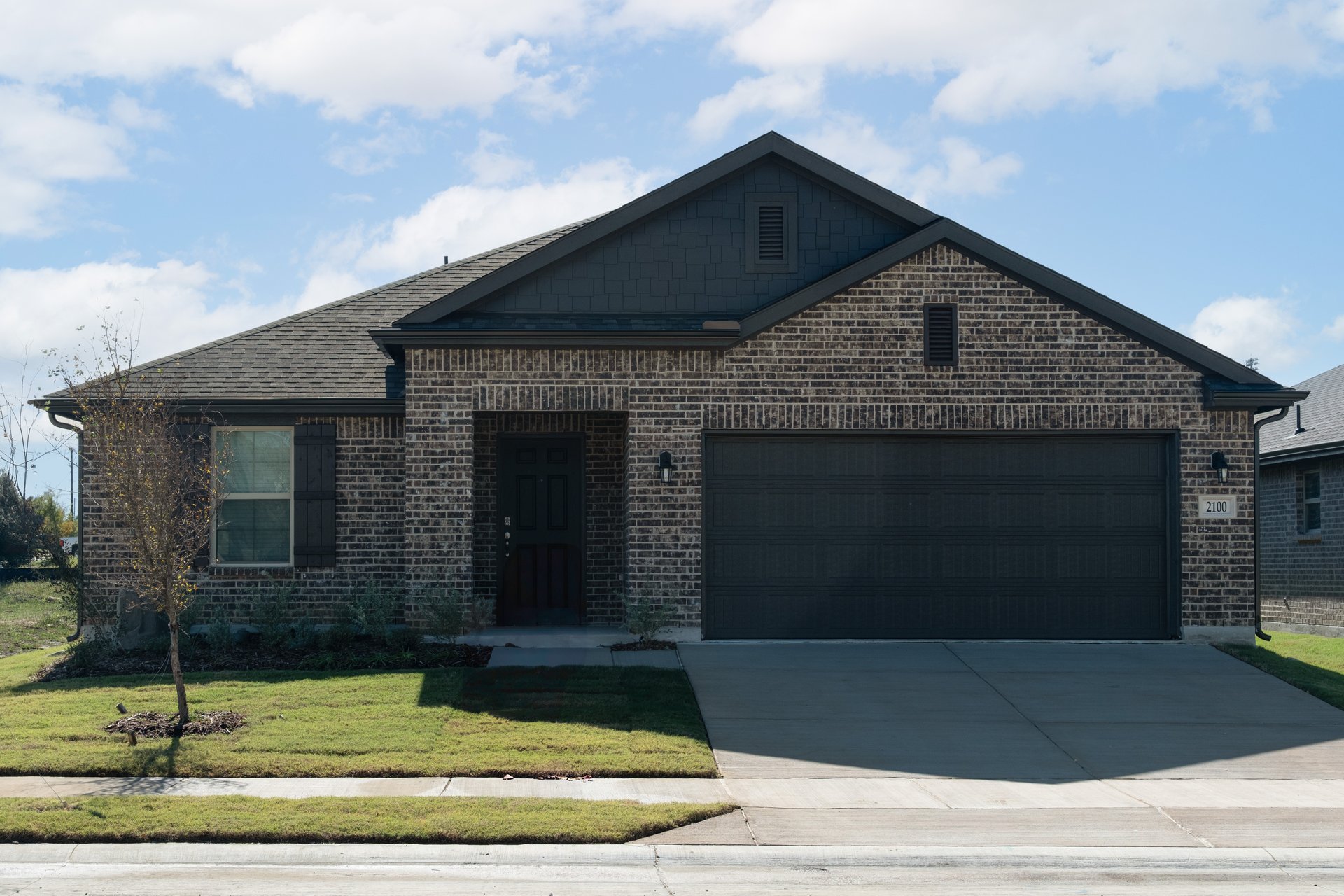exterior of home with brown brick and black siding