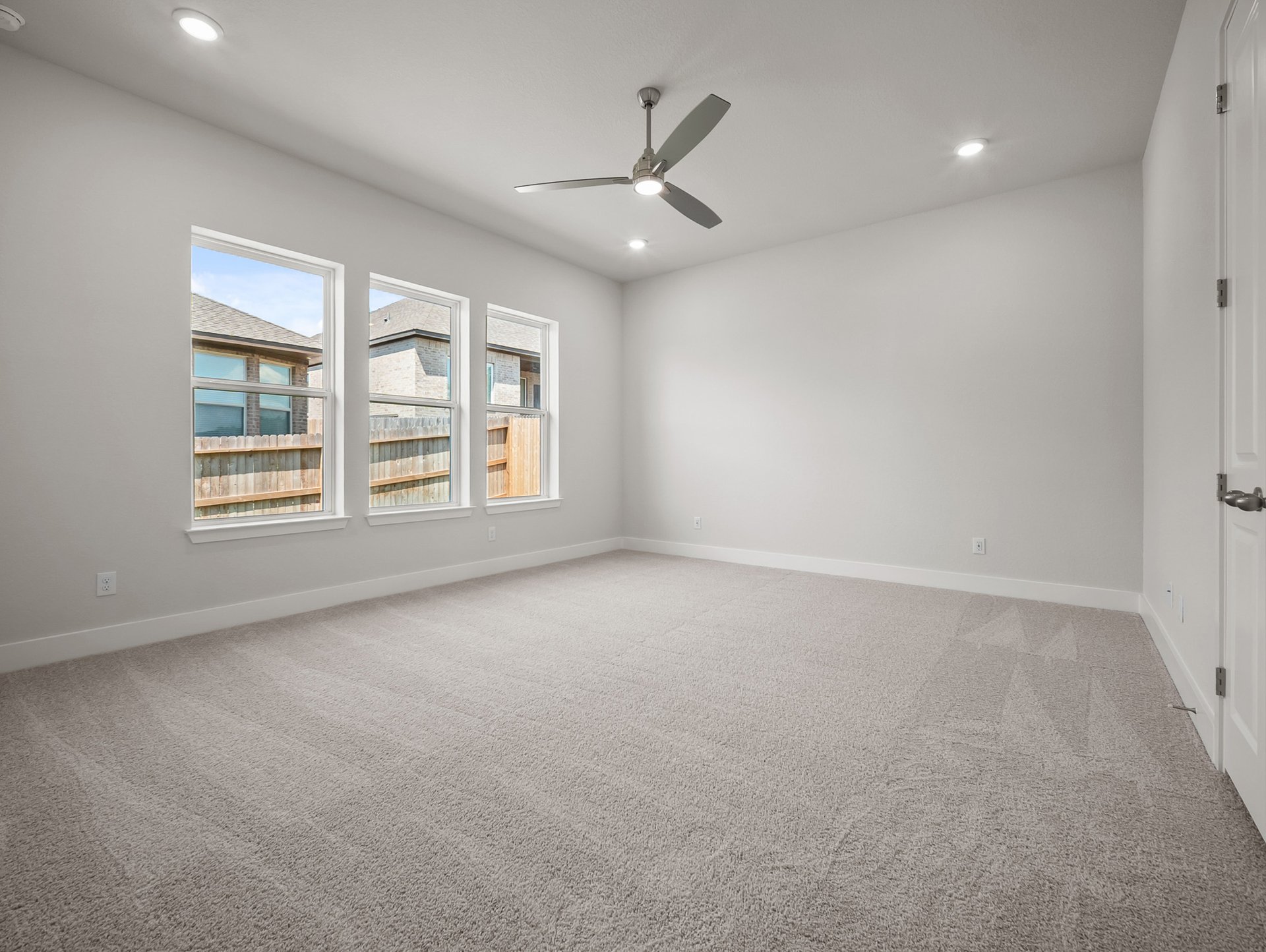 bedroom with carpet, ceiling fan & windows