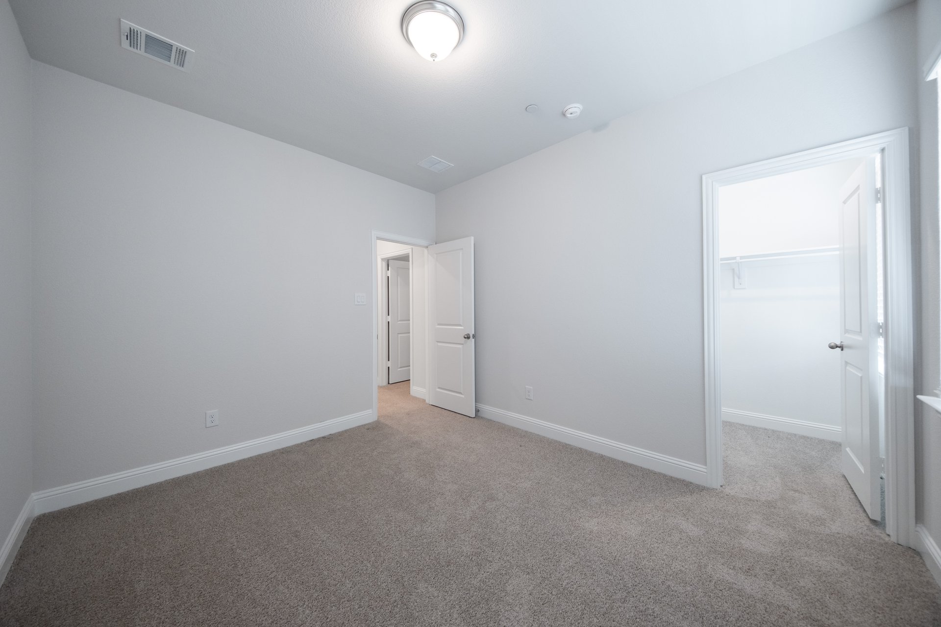 guest bedroom with carpet and walk-in closet
