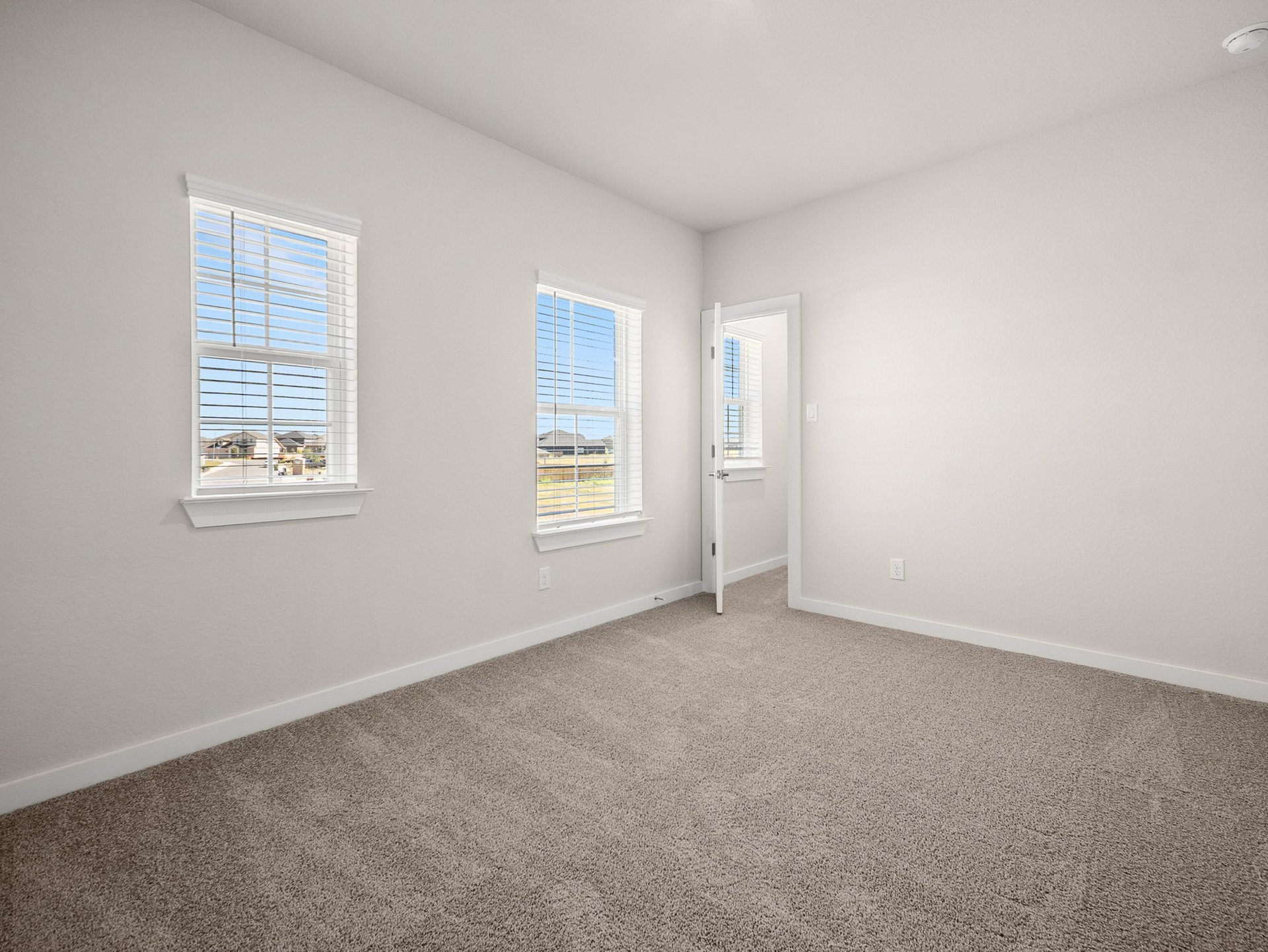 bedroom with windows, carpet & a sloped ceiling