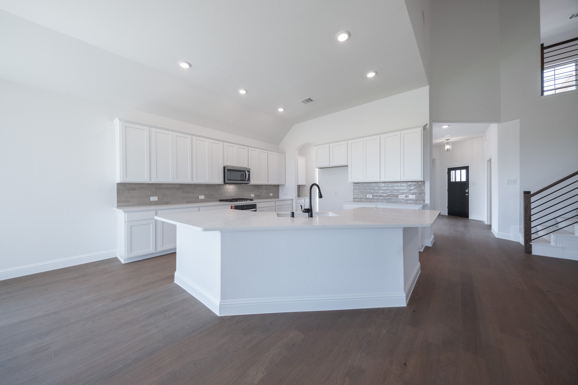 open kitchen with white cabinets and hardwood flooring