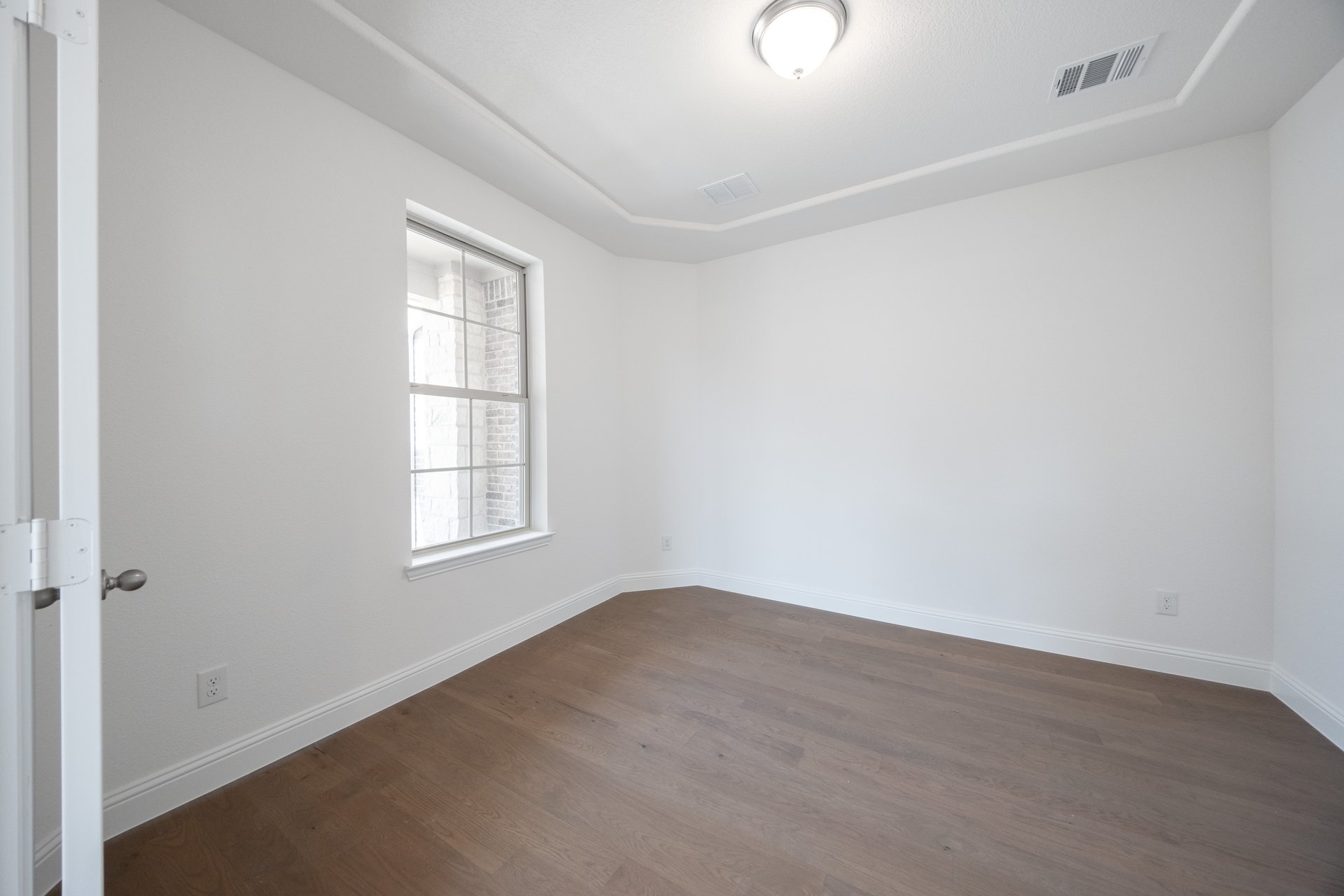 open study with hardwood flooring and glass french doors