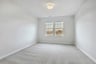 primary bedroom with two window and overhead light