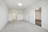 secondary bedroom with hallway to bathroom and door to great room