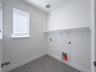 laundry room with tile flooring and storage shelf