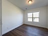 private study with hardwood flooring and window