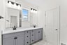 primary bathroom with two sinks and an oversized shower