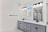 primary bathroom with two sinks and an oversized shower