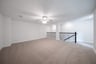 loft with carpet and ceiling fan 