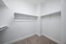 closet with hanging racks and carpet 