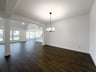 open dining room with wood floors and arch opening
