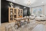 study room with a desk and large book case plus two white ottoman chairs in the corner
