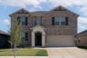 exterior of home with brown brick and white stone