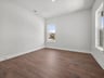 study with brown flooring, windows & recessed lighting