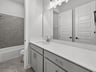 bathroom with quartz countertops & a tub with shower combo