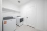 laundry room with tile flooring with storage shelf