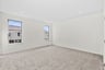 primary bedroom with multiple windows and carpet