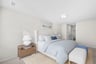 secondary bedroom with nightstand, bed, and ottoman 