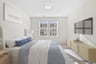 primary bedroom with nightstand, bed, and ottoman