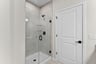 primary bathroom with shower with black hardware and tile
